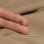 a person's hand holding a tiny gold bird ring