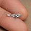 a small airplane shaped silver ring on a finger
