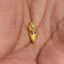 A small gold-colored flower-shaped earring is being held in a person's hand.