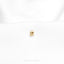 a close up of a gold pin on a white shirt