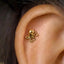 A gold-colored octopus-shaped earring is visible in the person's ear.