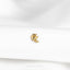 a close up of a gold brooch on a white shirt