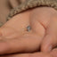 a person's hand holding a tiny silver object