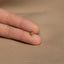 a person's hand holding a tiny gold ring