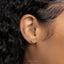 a close up of a person's ear with a gold earring