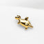 a gold giraffe brooch sitting on top of a white surface