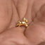 A small, golden rabbit figurine is being held in a person's hand.