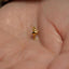 a tiny gold star shaped object on a persons hand