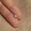 a person's finger with a small diamond ring on it