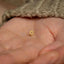 a small gold star of david stud in someone's hand