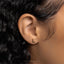 a close up of a person's ear with a gold nose piercing