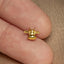 a person's finger with a small gold animal ring on it