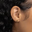 a close up of a person's ear with a gold earring