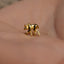a close up of a person wearing a gold monkey ring