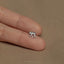 a person's hand holding a tiny silver elephant ring