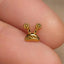 a close up of a person's finger with a small gold snail charm on