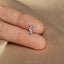 a person's hand with a tiny nose ring on it