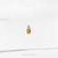 a close up of a gold earring on a white surface