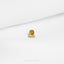 a close up of a small gold object on a white surface