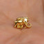 a small gold elephant charm on a person's hand