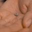 a close up of a person's hand holding a ring
