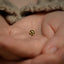 a baby's hand holding a tiny yellow and black ball
