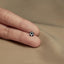 a person's hand holding a tiny black and white bead