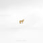 a small gold horse pin sitting on top of a white surface