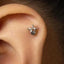 A small silver earring with a decorative design is visible in the person's ear.