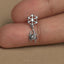 A small silver-colored charm in the shape of a spider is being held between two fingers.