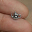 a person's hand holding a tiny silver teapot charm