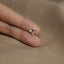 a person's hand holding a tiny silver ring