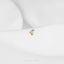 a pair of gold earrings on a white surface