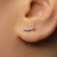 A close-up of a person's ear with a small silver earring in the earlobe.