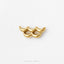 A single gold-colored gemstone in the shape of a wave, placed on a white background.