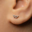 A close-up view of a person's ear with a small silver earring in the earlobe.