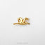 A single gold-colored metal piece, resembling a wave or swoosh, is displayed against a white background.
