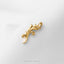 A gold leaf-shaped brooch is displayed against a white background.