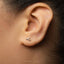 A close-up view of a person's ear with a small silver earring in the earlobe.