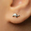 A close-up view of a person's ear, showing a small silver earring with a turtle design.