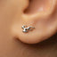 a close-up view of a person's ear with a small silver earring in the earlobe.
