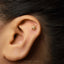 A gold earring with a star-shaped design is visible in the image.