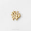 A small gold-colored piece of jewelry, resembling a coral or plant-like structure, is shown against a plain white background.