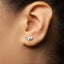 A close-up view of a person's ear adorned with a small, silver earring.