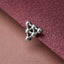 A silver-colored metal object resembling a crystal or molecule is placed on a textured purple surface.