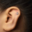 A silver earring with a lion's head design is visible in the person's ear.