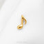A small gold-colored musical note pin is resting on a white fabric surface.
