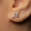 a close-up view of a person's ear with a small, silver earring featuring a design resembling a brain or nervous system.