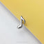 A silver music note-shaped earring is placed on a yellow background.