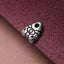 A silver metal charm in the shape of a pentagram, with the letters "YN" drawn on it, is resting on a textured purple surface.